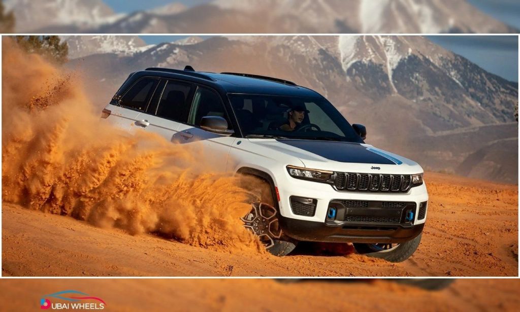 2025 Jeep Grand Cherokee showing strong desert performance in UAE sand dunes with traction control and terrain modes active